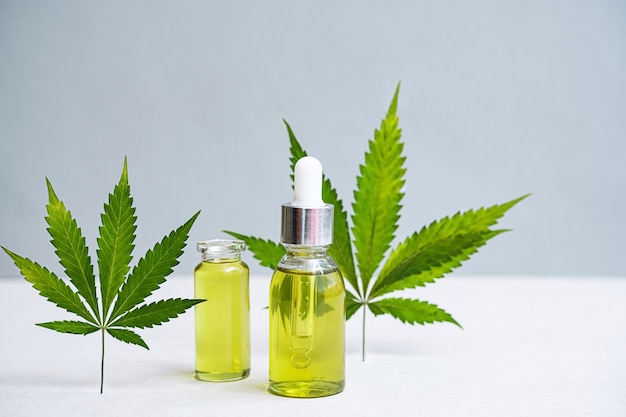 Cosmetics CBD oil and leaves of cannabis  glass bottles with Hemp oil