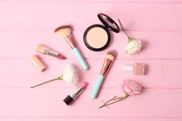 Cosmetics and flowers on a colored background top view