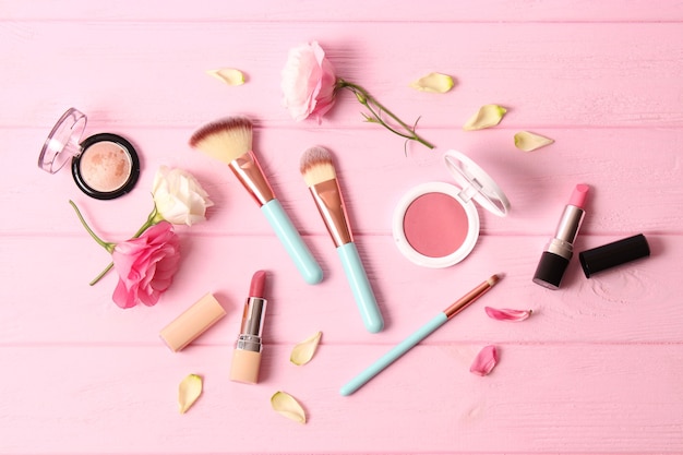 Cosmetics and flowers on a colored background top view