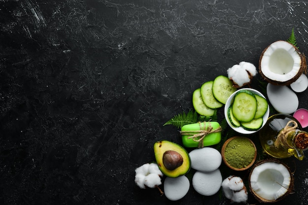 Cosmetics from green cucumber on black stone background The concept of cosmetics and spa Top view Free copy space