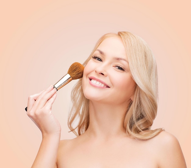 cosmetics, health and beauty concept - beautiful woman with closed eyes and makeup brush