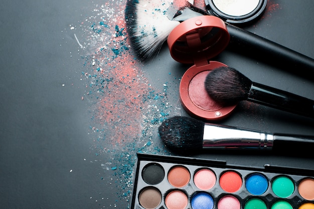 cosmetics for makeup and brushes on a black table