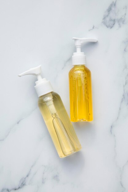 Cosmetics product bottles with natural oils on a marble background