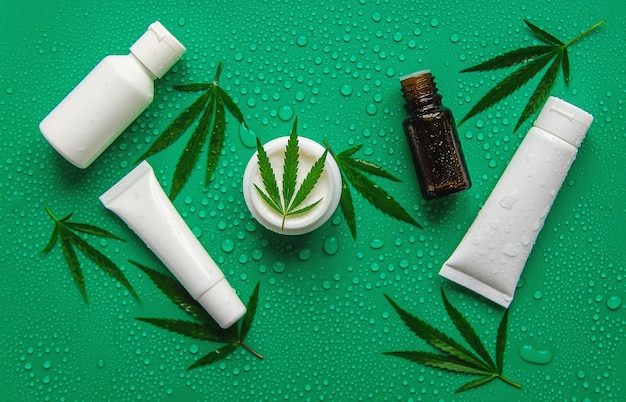 Cosmetics with cannabis extract on a wet background Selective focus