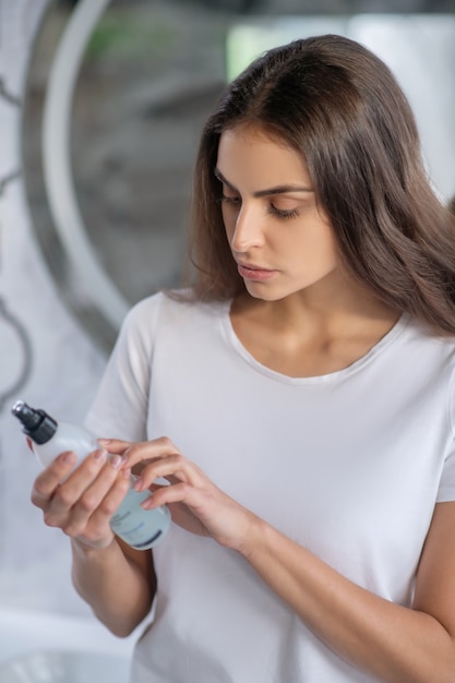 Cosmetisch product. Een vrouw met een fles nieuwe haarlak