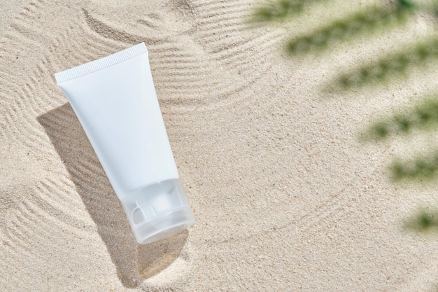 Cosmetisch product in buis op aardachtergrond met zand Essentiële crème voor het hydrateren van lichaamshuid gezichtsverzorging sunblock mockup van schoonheidsmode cosmetisch flesdruppelproduct met huidverzorgingsconcept