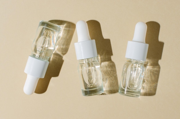 Cosmetisch product in een fles met een pipet Serum voor huid of haar Platte lay-out Beige achtergrond