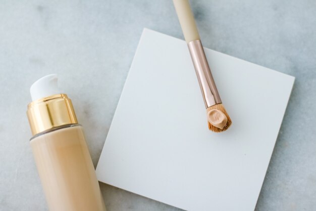 Cosmetische branding glamour en huidverzorging concept make-up foundation fles en contourborstel op mar ...