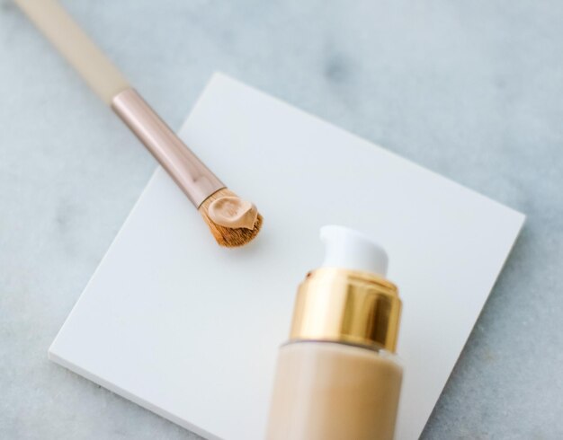 Cosmetische branding glamour en huidverzorging concept make-up foundation fles en contourborstel op mar ...