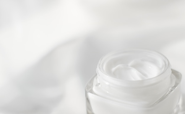 Cosmetische branding toiletartikelen en spf concept gezichtscrème moisturizer pot op zijde achtergrond hydraterende huidverzorging lotion en opheffende emulsie antiage cosmetica
