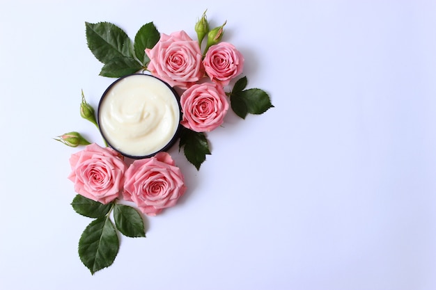 Cosmetische crème en bloemen op een gekleurde close-up als achtergrond
