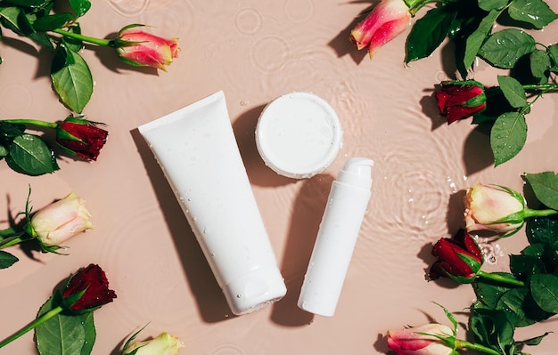 Cosmetische crème gel serum witte fles op een achtergrond van water en verse bloemen