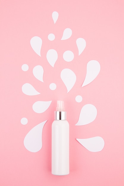 Cosmetische fles met papier gesneden spatten.