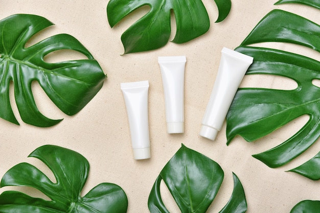 Cosmetische flescontainers verpakking met groene kruidenblaadjes, blanco label voor biologisch merkmodel