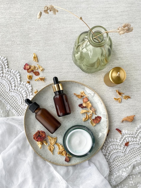 Cosmetische flessen en een potje room op een bord