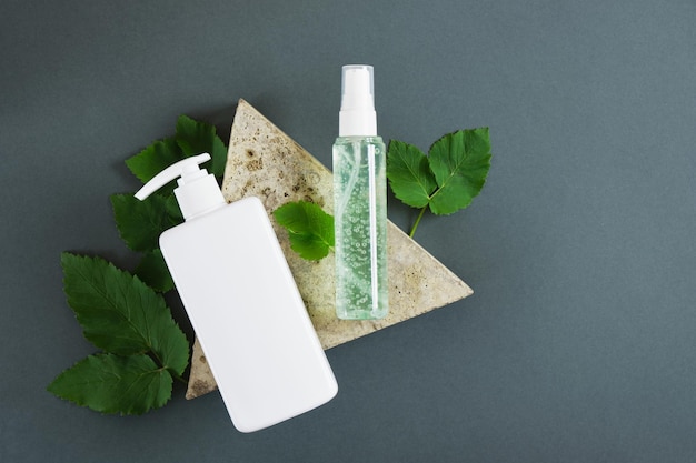 Cosmetische flessen en verse munt op donkergroene achtergrond. Biologisch cosmetica-concept. Cosmetische containers mockup