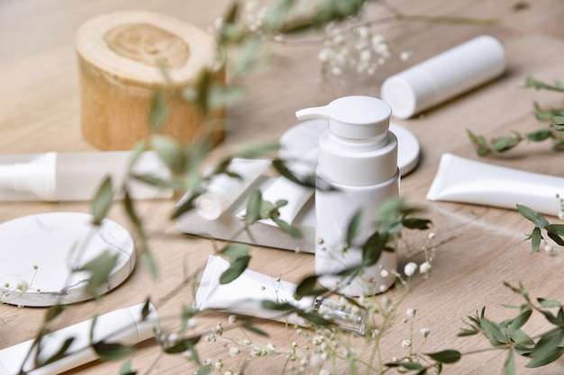 Foto cosmetische flesverpakkingen met groene kruidenbladeren, blanco label voor organische branding, natuurlijke huidverzorging schoonheidsproductconcept.