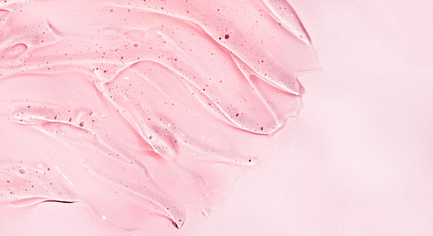 Cosmetische gel met hyaluronzuur. Cosmetische heldere vloeibare transparante crème. Huidverzorgingsproduct op roze achtergrond.