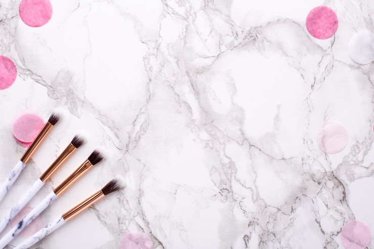 Foto cosmetische penselen met roze decoraties op marmer