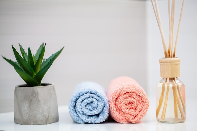 Cosmetische producten en katoenen handdoeken op witte houten tafel in de schoonheidssalon