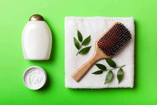 Cosmetische voor haarverzorgingscrème en handdoek op een gekleurde achtergrond bovenaanzicht plat lag