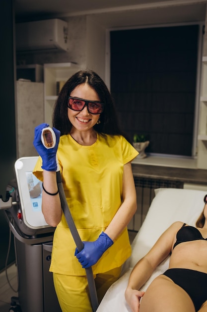 Cosmetologie jonge vrouw met een mooi lichaam in de spa salon die laserontharingsprocedure ontvangt