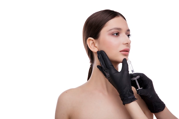 Cosmetologie schoonheid concept mooie jonge vrouw gezicht en hand met spuit maken van injectie
