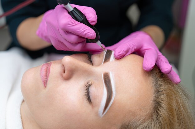 Cosmetologist applying permanent make up