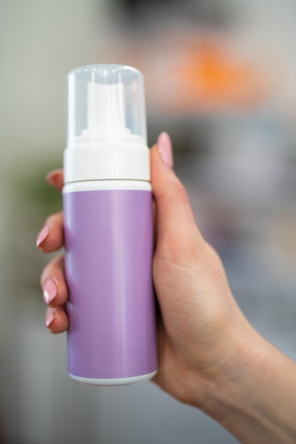 Cosmetologist holding a can with a cosmetic product for the skin