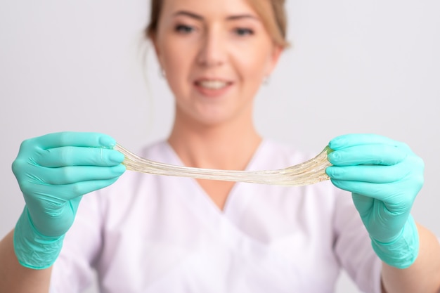 Cosmetologist holds sugar paste.