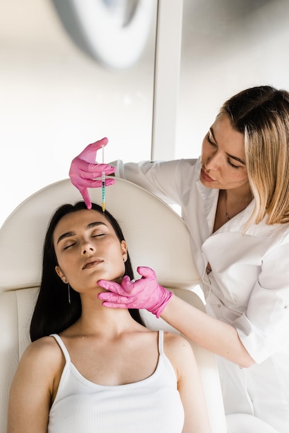 Косметолог проводит инъекционную биоревитализацию лица для увлажняющего эффекта Биоревитализация лица для повышения тонуса кожи, уменьшения морщин и укрепления овала лица