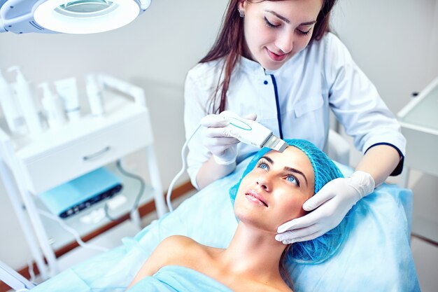 The cosmetologist is caring for the patient's face