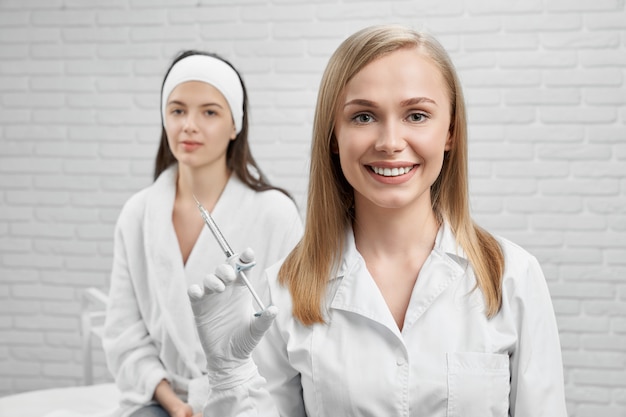 Cosmetologist looking at camera, smiling and keeping prick