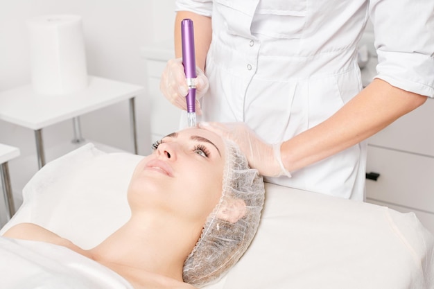 Cosmetologist maakt mesotherapie-injectie voor verjonging vrouw gezicht procedure in schoonheidssalon