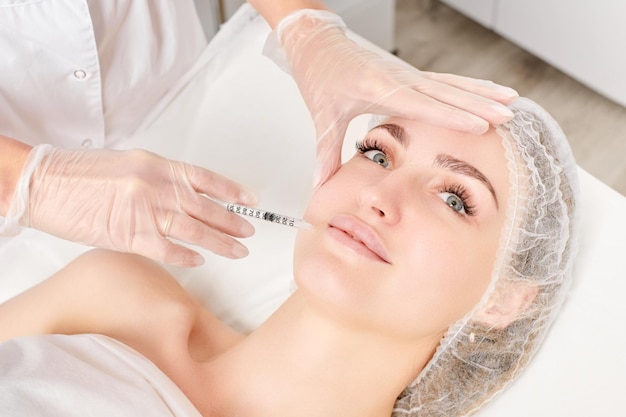 Cosmetologist maakt vulstoffen injectie voor lippenvergroting en volume cosmetische procedure