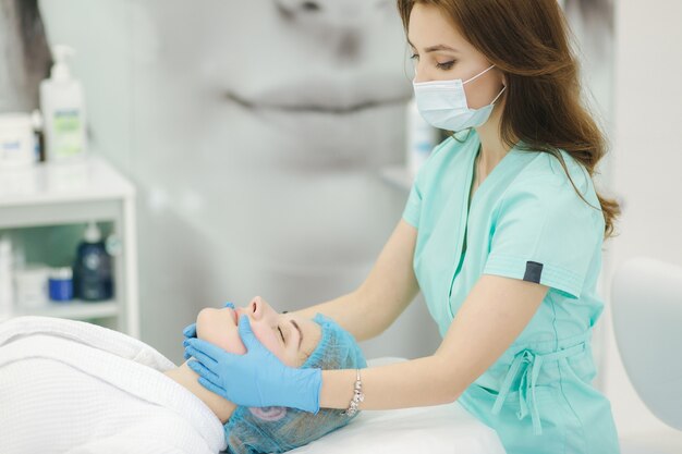 Photo cosmetologist make facial massage in beauty salon