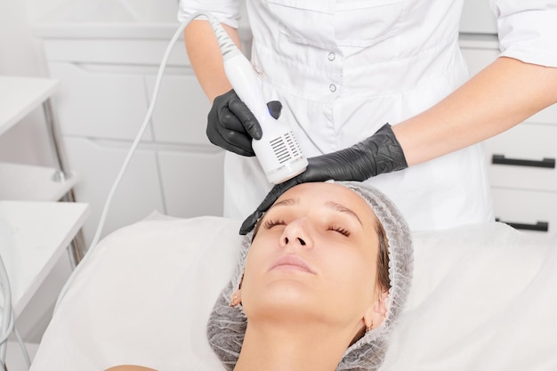 Cosmetologist makes cryotherapy for rejuvenation woman face anti aging procedure in salon