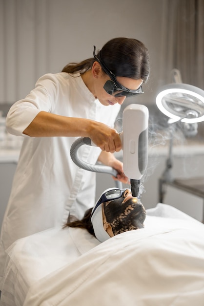 Cosmetologist makes laser carbon peeling