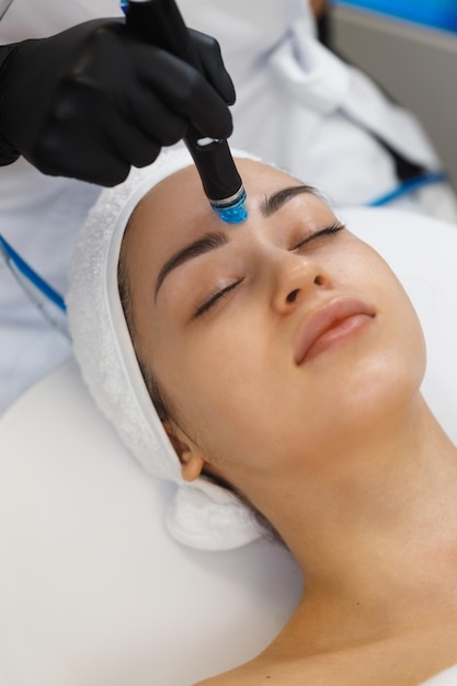 Cosmetologo che fa un'iniezione di mesoterapia con dermapen sul viso per il ringiovanimento nel centro termale