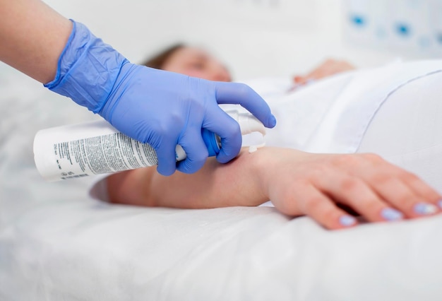 Photo a cosmetologist performs depilation on a girl's arm massage sugaring epilation with sugar paste