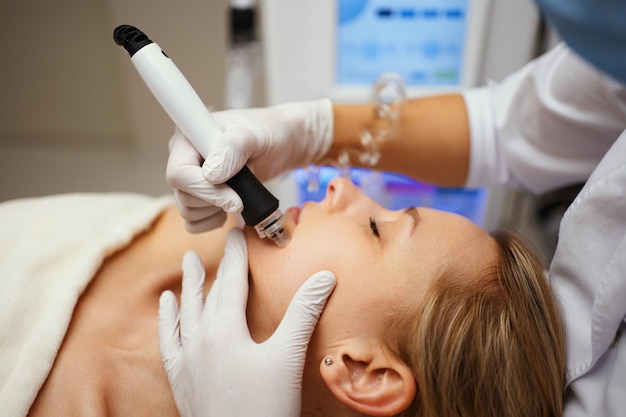 A cosmetologist performs hydropiling in a beauty salon Skin care