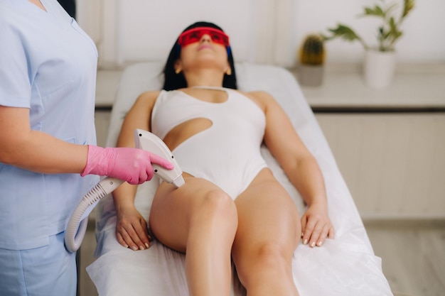 A cosmetologist performs a laser hair removal procedure in the office