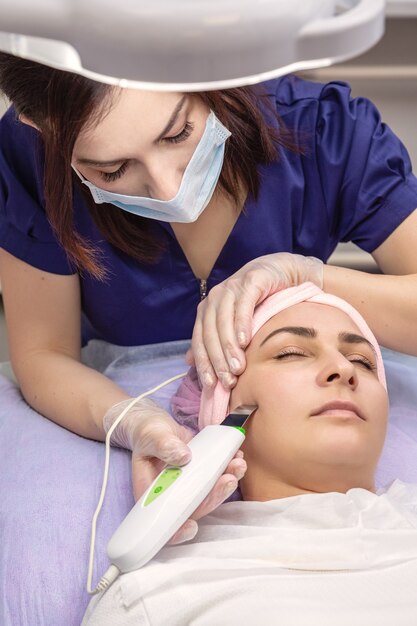 Cosmetologist performs phonophoresis procedure for the skin