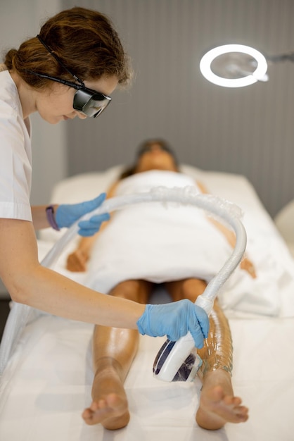 Cosmetologist removing hair with a laser epilator