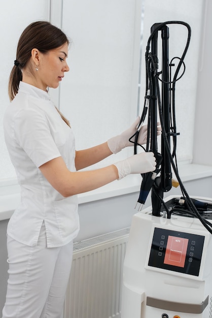 Foto un cosmetologo installa un dispositivo moderno con un laser in un salone di bellezza gli impulsi laser puliscono la pelle cosmetologia hardware il processo di fototermolisi che riscalda la pelle