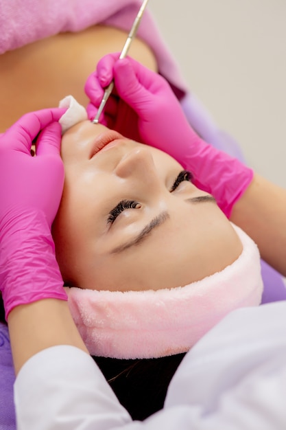 Косметолог в спа салоне красоты делает лечение акне с помощью механического инструмента. Концепция лечения омоложения и ухода за кожей