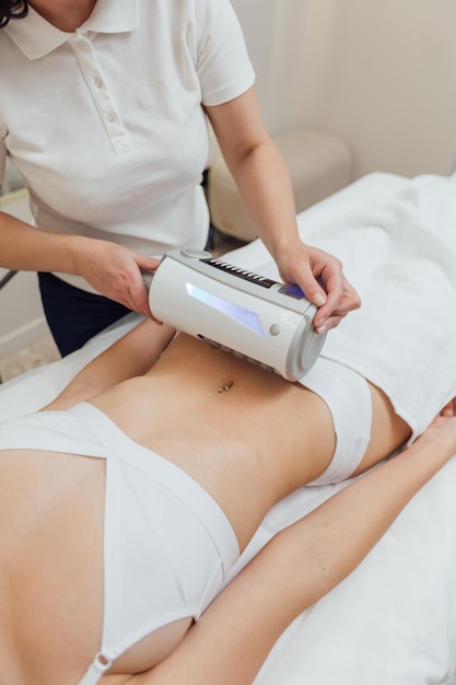 Cosmetologist uses endospheres device on a female body in beauty clinic