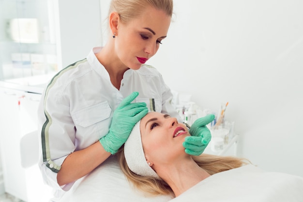 Cosmetologist at work Young woman doctor preparing patient to beauty procedures