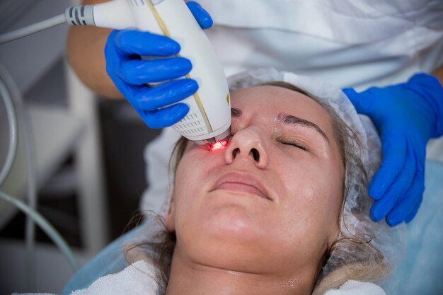 Foto clinica di cosmetologia una procedura di assunzione del cliente che lavora con uno strumento