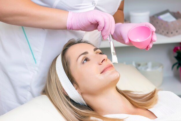 Cosmetology. young woman with receiving facial cleansing procedure in beauty salon.